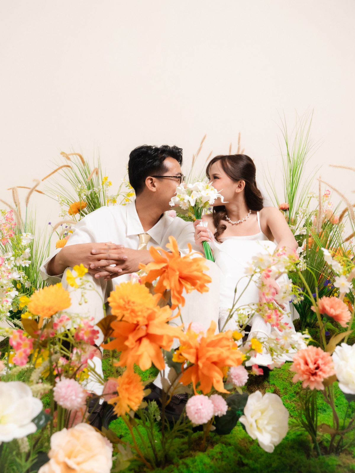 Pasangan pada sesi foto prewedding di Surabaya — set taman bunga Spring Blossom dalam studio, cahaya sore, foto 59 dari 80